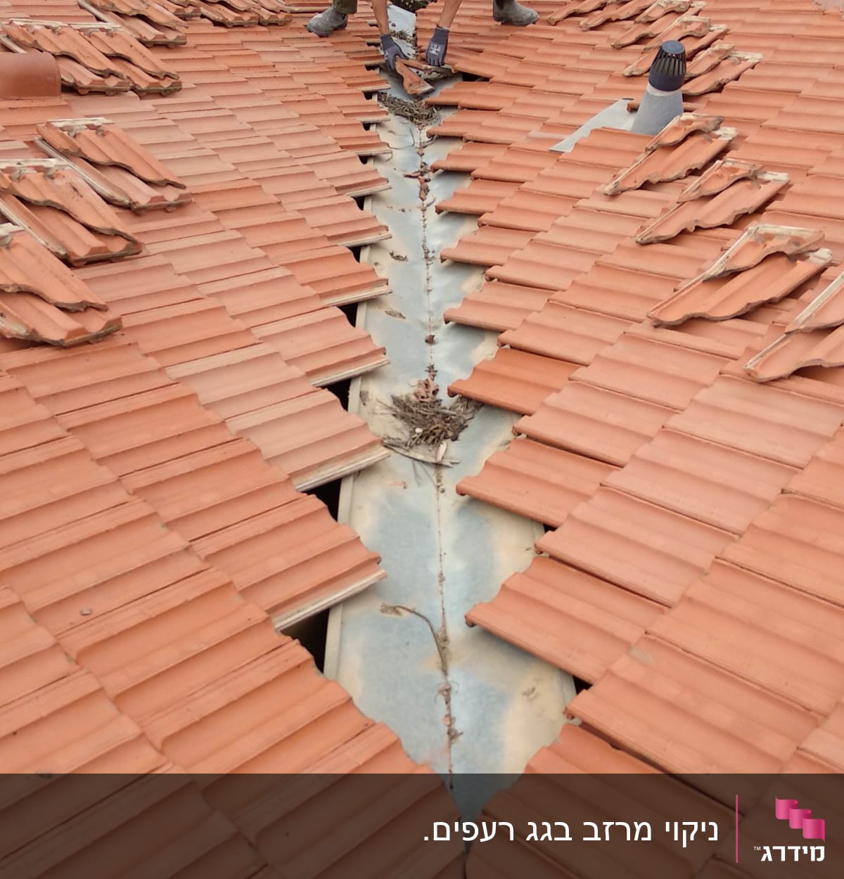 אדם מתקן רעפים על גג רעפים אדום